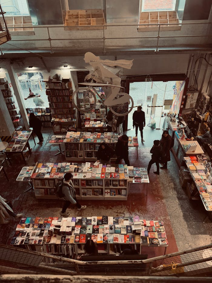 about-bg Explore the inviting atmosphere of a Lisbon bookstore with visitors browsing shelves.